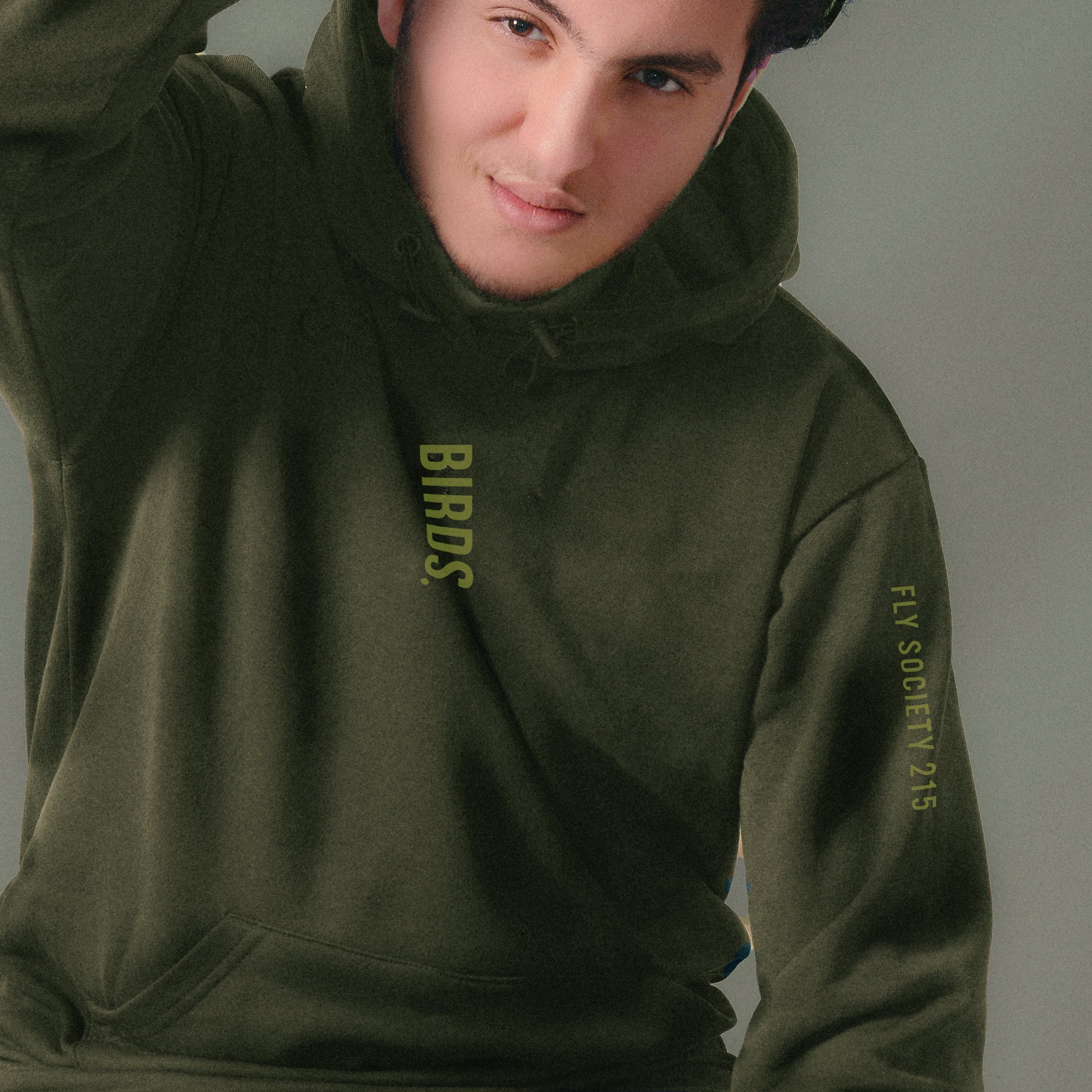 Person wearing a green hoodie with text on a plain background