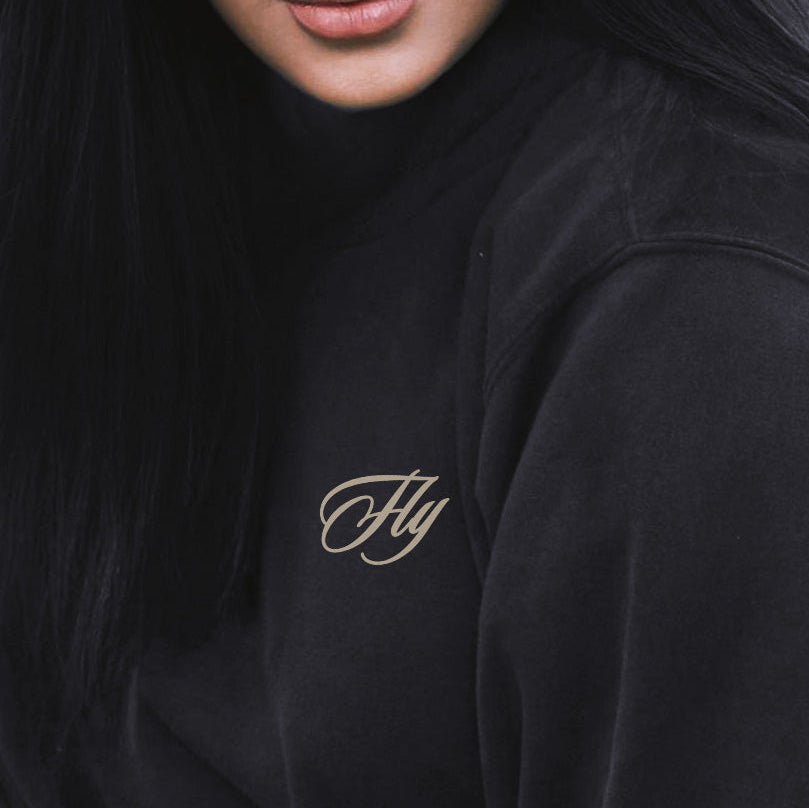 Person wearing a black hoodie with 'Fly' logo, sunglasses on head