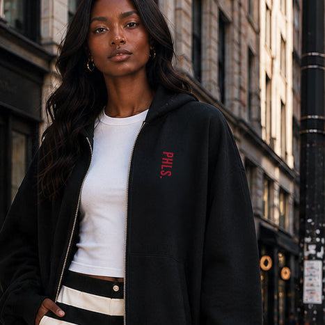 Woman in a stylish outfit with a red handbag on a city street