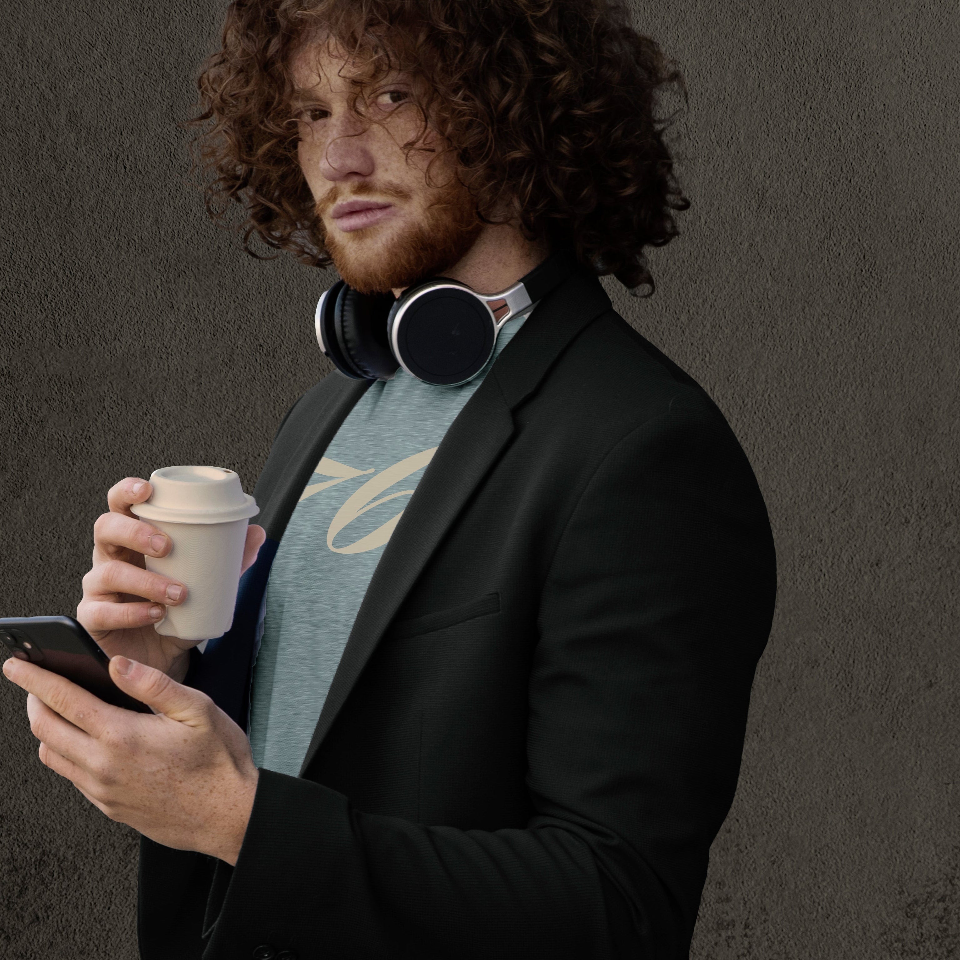 Man in a suit holding a coffee cup and phone against a dark background