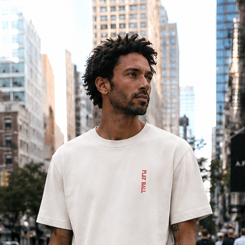 Man in a white t-shirt and shorts standing on a city street