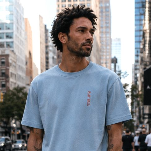 Man wearing a light blue t-shirt with text in an urban setting