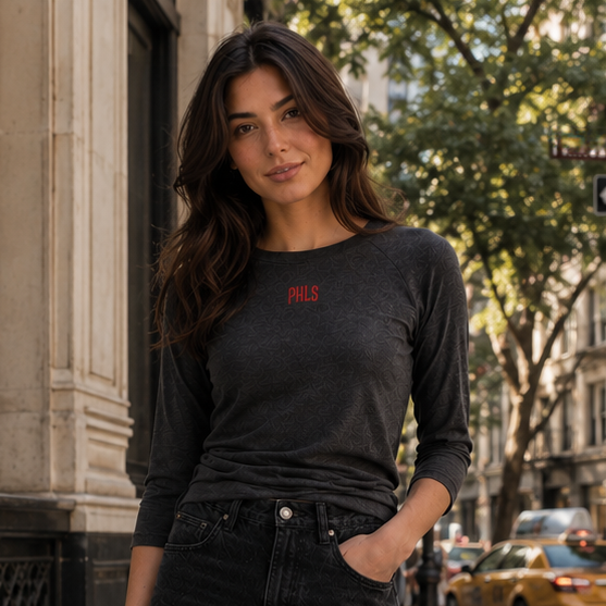 Woman in black outfit holding a brown bag on a city street