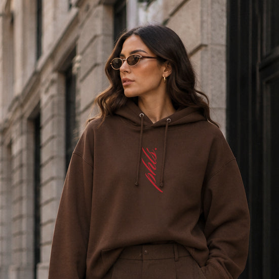 Woman in a brown outfit standing on a city street