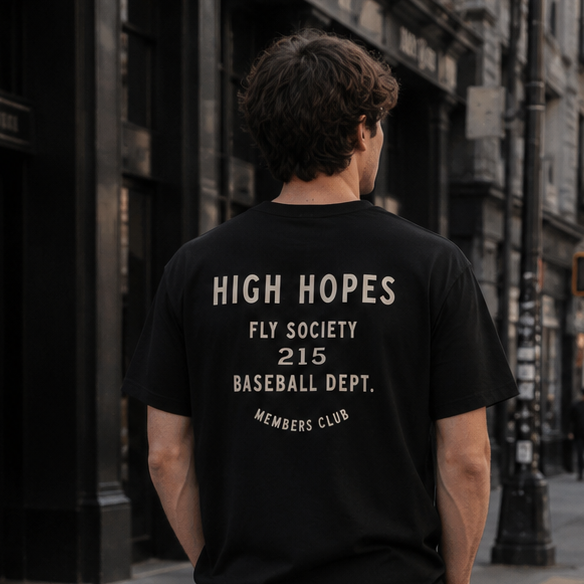 Person wearing a black t-shirt with text standing on a city street.
