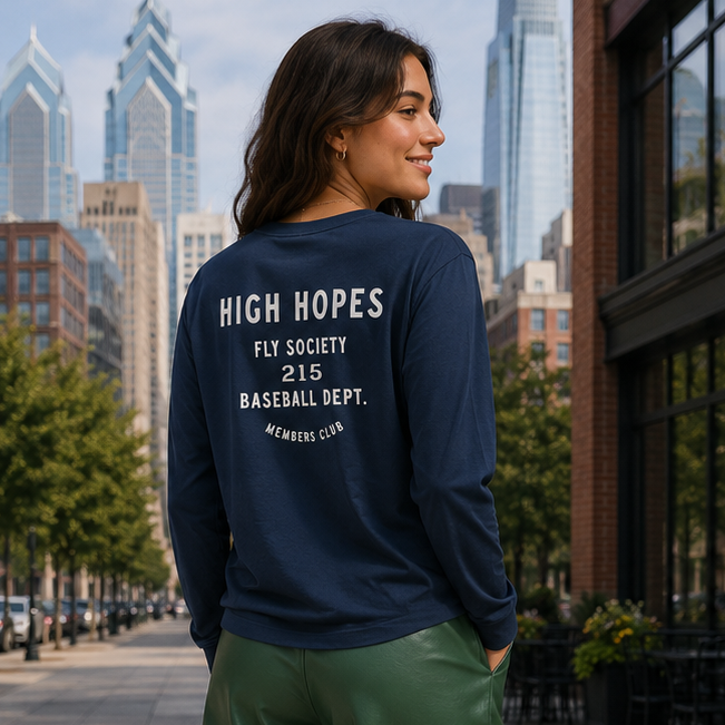 Woman wearing a navy sweatshirt with text on the back, standing on a city street.